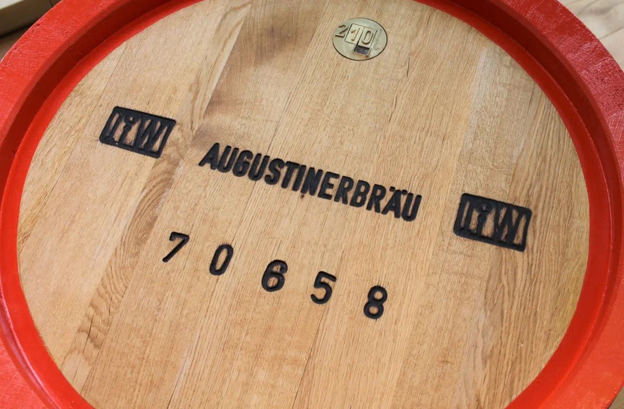 Nahaufnahme eines Holzfasses mit rotem Rand der Brauerei Augustinerbräu.
