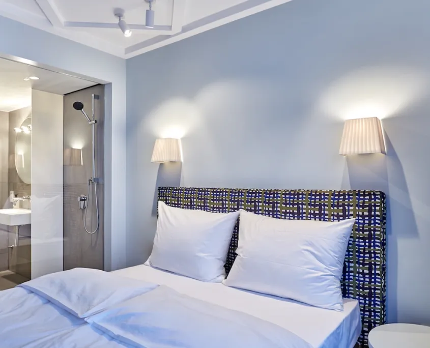 Doppelbett mit Blick auf die Dusche