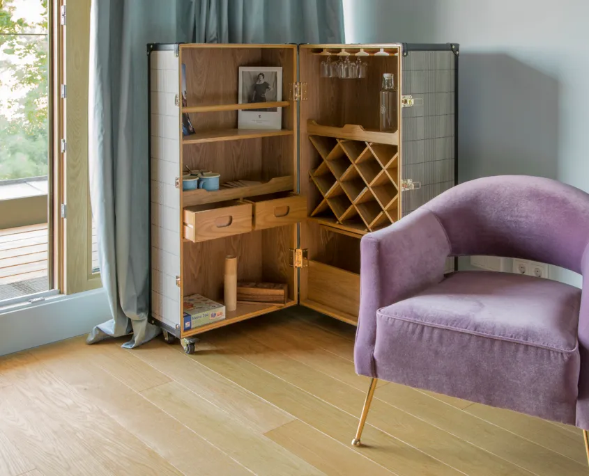 Zimmer mit Schrankkoffer und lila Sessel